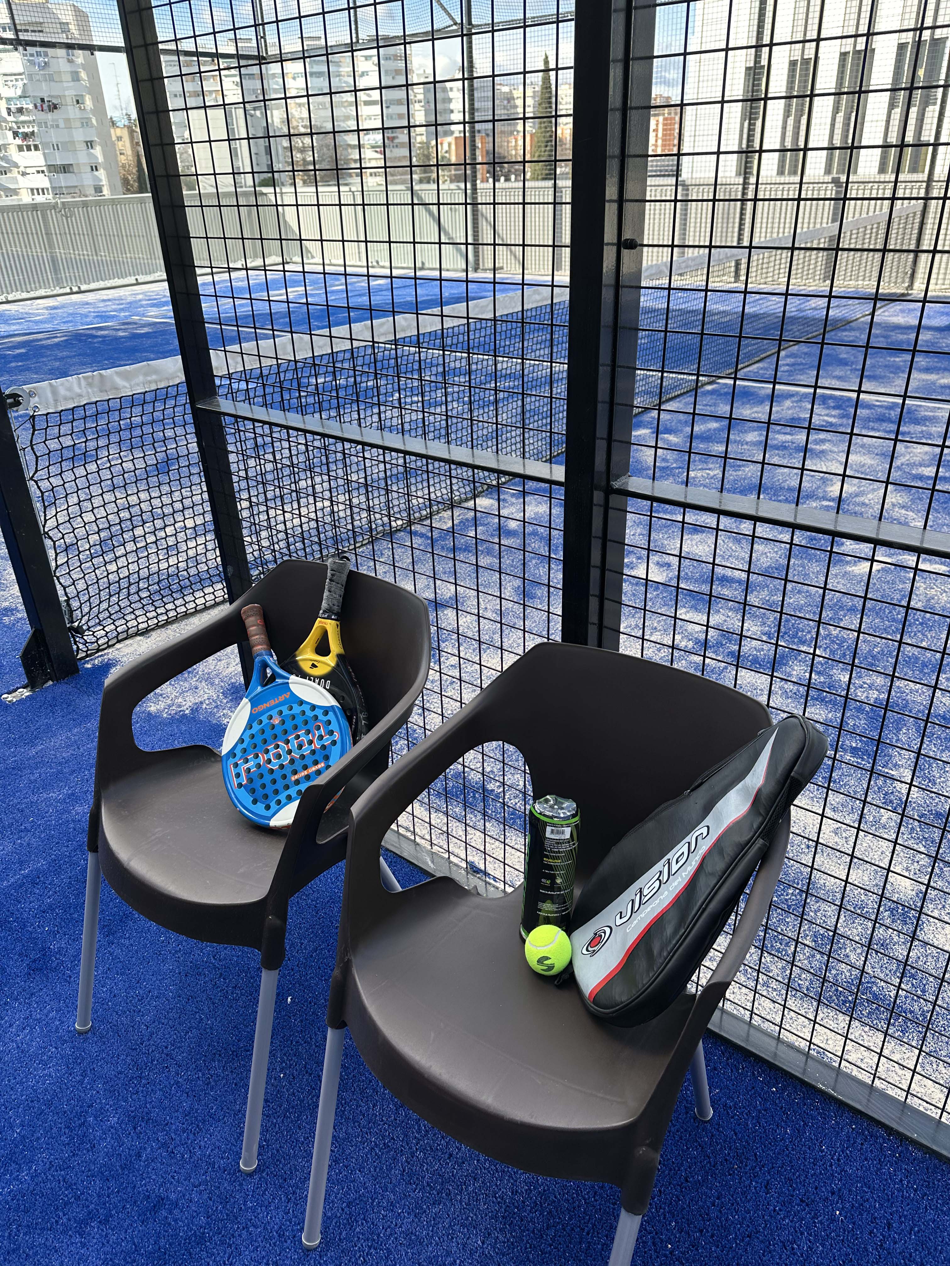 Sillas con material deportivo en la pista de padel en Madrid de Cityo